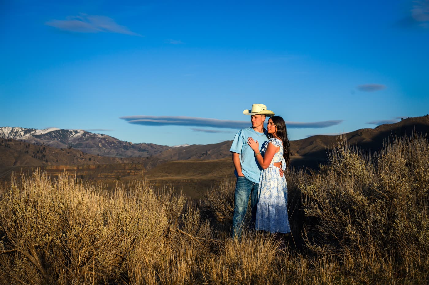 Engaged couple embracing in the Idaho mountains at golden hour